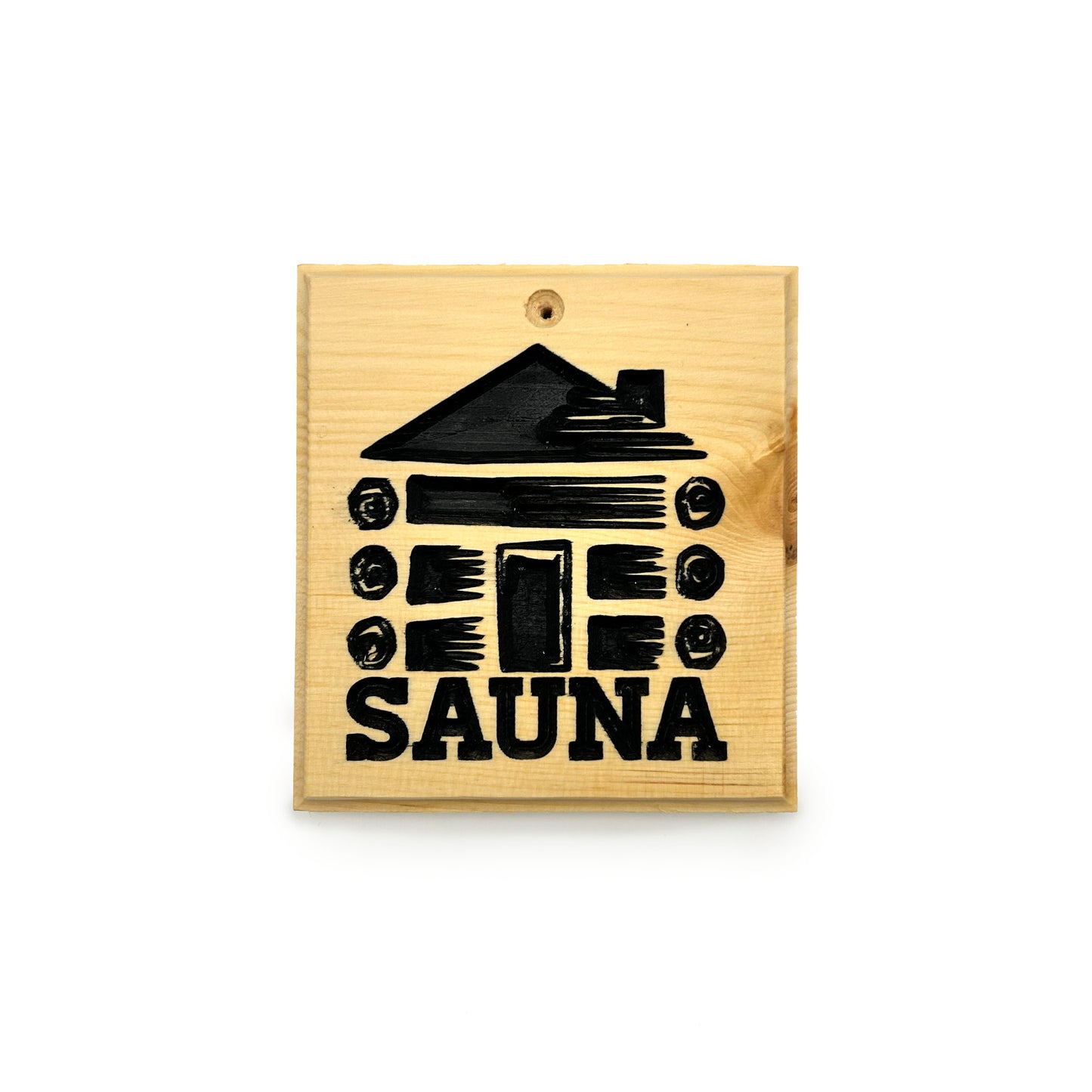 A square wooden sauna plaque or sign with a black engraved graphic of a log cabin and the word 'SAUNA' in bold letters, shown on a plain white background.